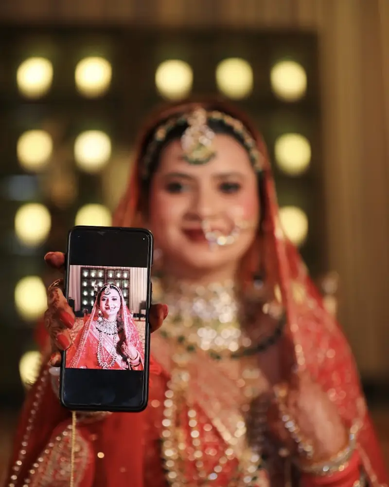 Bride holding up a phone showing her own portrait.